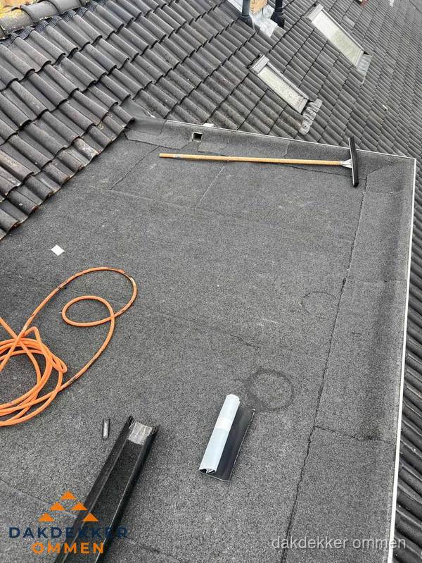 Plat dak reparatie met gereedschap en loodstroken in Ommen Plat dak reparatie met gereedschap en loodstroken in Ommen